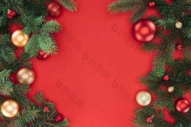 平躺在松树树枝与红色和金色的圣诞球查出的红色