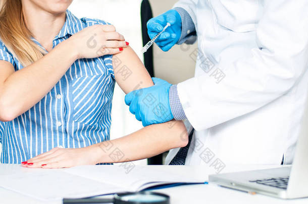 接种.流感疫苗医生向病人的手臂注射流感疫苗