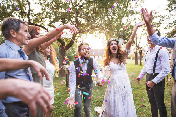 新娘, 新郎和客人扔五彩纸屑在婚礼招待会外面.