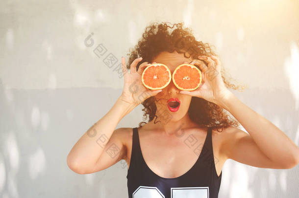 年轻妇女抱着葡萄柚而不是站在您的广告内容的复制空间区域在夏天的眼镜
