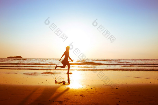 女孩在日落时在<strong>沙滩</strong>上跑