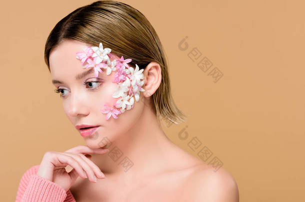 温柔的女孩与鲜花在脸上孤立在米色