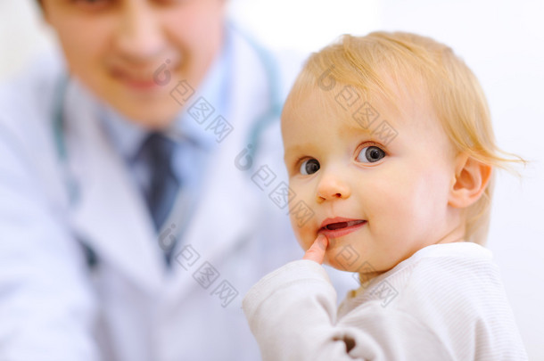 背景中的婴儿和儿科医生的肖像
