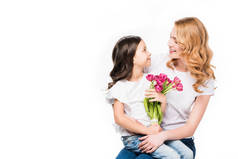 愉快的母亲和小女儿与花束被隔绝的花在白色, 母亲节假日概念