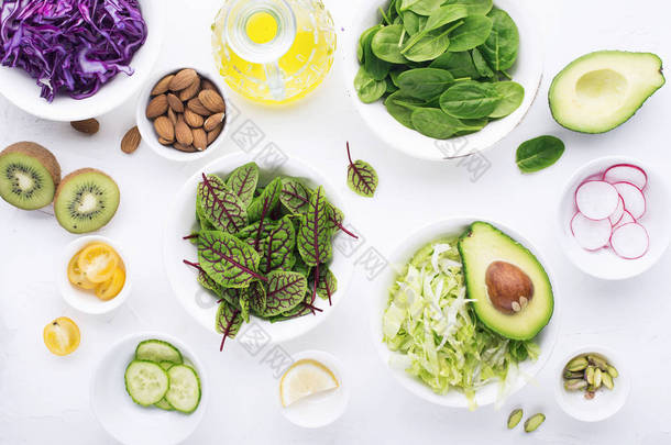 干净的食物。新鲜的生蔬菜和生菜叶准备健康的零食沙拉。顶部视图。在浅色背景上.