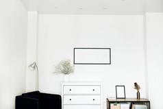 家居设计室内配有相框, 白色花花束和抽屉柜, 白色背景扶手椅。最小斯堪的纳维亚概念.