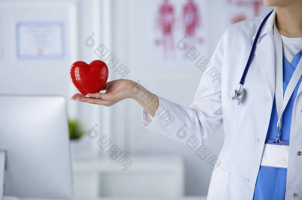 带听诊器心脏的女医生，背景浅