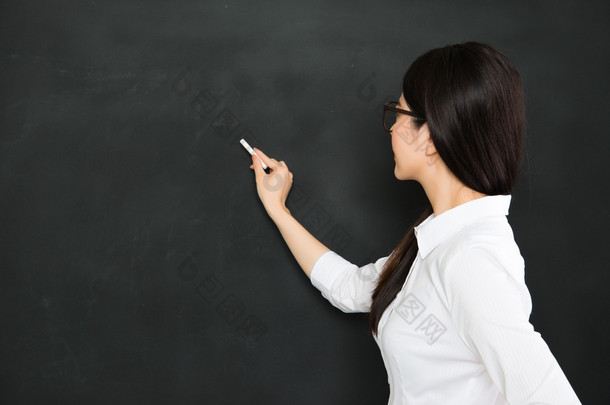 一个好的亚洲老师写在<strong>黑板上用粉笔</strong>