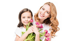 幸福的母亲和小女儿的肖像与花束的花朵隔离在白色, 母亲节的概念
