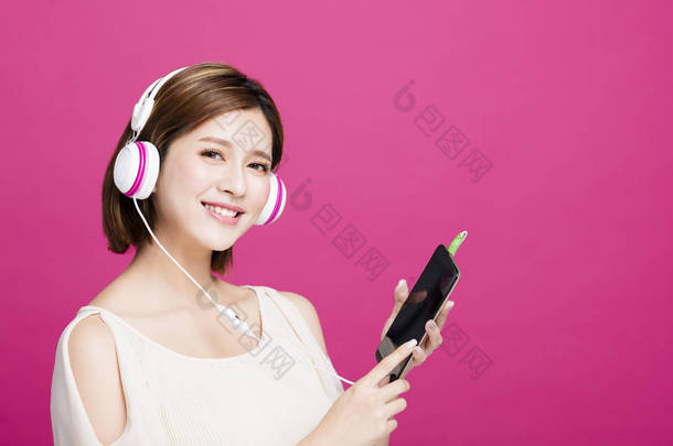 女人听<strong>音乐耳机</strong>与智能手机