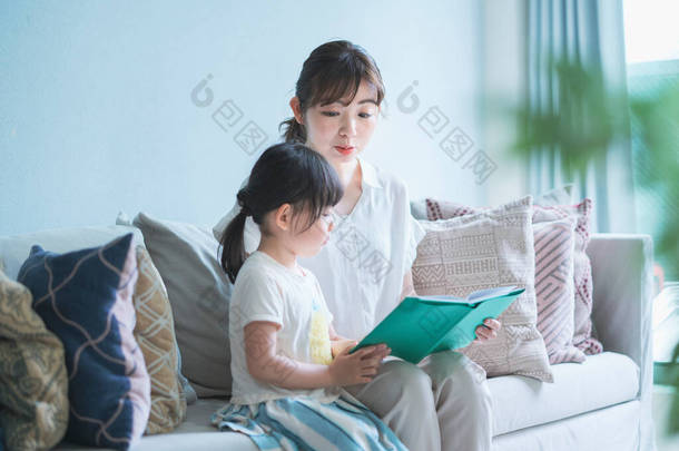 母亲和女儿坐在沙发上看<strong>画册</strong>
