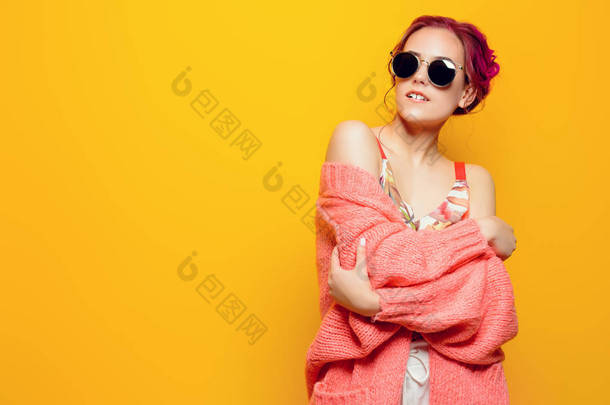 美丽的女孩, 粉红色的头发穿着鲜艳的衣服在黄色背景。明亮的风格, 时尚.