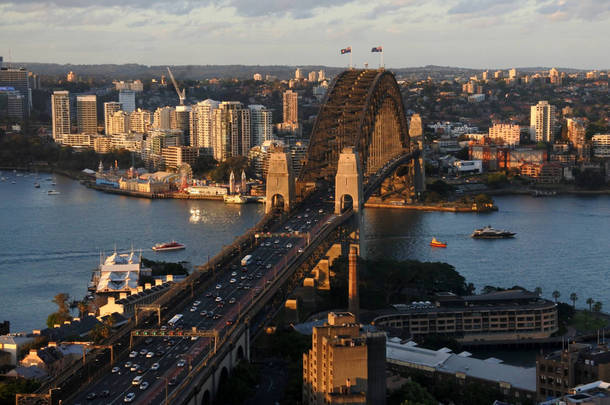 在澳大利亚新南威尔士州悉尼, 悉尼海港大桥在日落时与北悉尼和岩石的空中城市景观景观.