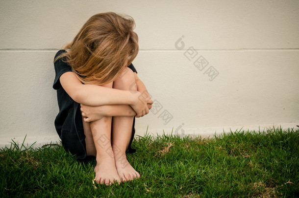 悲伤的小女孩，在<strong>一</strong>天的时间坐在靠近墙的肖像