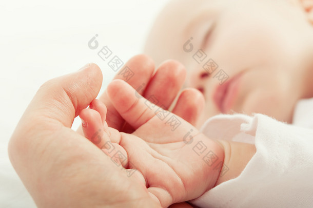 睡着的<strong>孩子</strong>在母亲的手的手