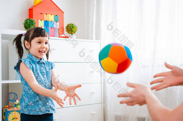 小女孩在儿童游戏室里玩耍，扔球。互动的概念父母和孩子，沟通，相互游戏，隔离，自我隔离的家，<strong>教育</strong>.