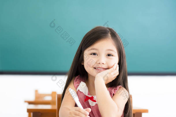 <strong>快乐</strong>的小女孩在教室里的桌子上写东西