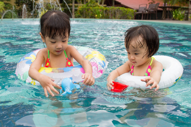 亚洲小的中国女孩在游泳池里玩