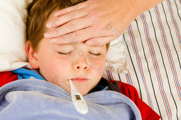 生病的孩子男孩正在发烧和病在<strong>床上</strong>休息的同时检查