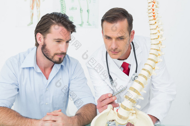 向患者解释脊柱的男医生