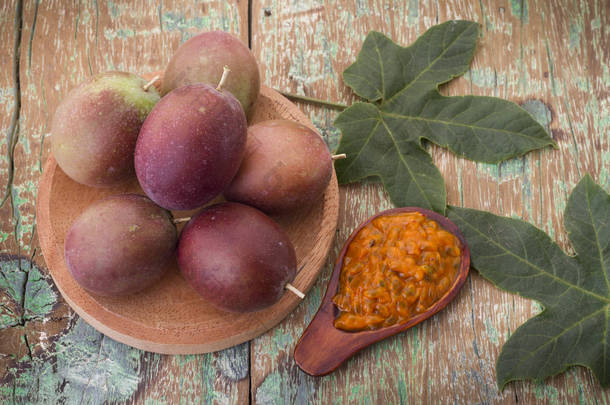 百香果和它的果肉在木制的<strong>背景</strong>下，原产于美国南部的水果.