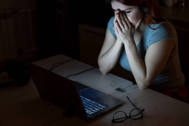 女人加班。<strong>一个</strong>晚上在黑暗中在笔记本电脑前学习的学生。3.这个女孩为工作中的问题忧心忡忡，两手空空.