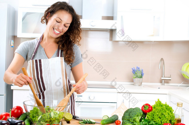烹饪的年轻女子。健康食品-蔬菜沙拉
