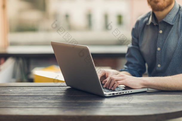 人在户外的桌子上用一台笔记本电脑