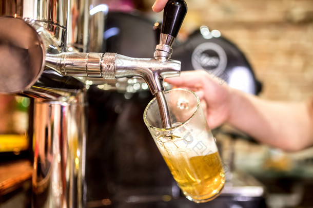 在啤酒的酒保手点击浇注在餐厅或酒吧服役的啤酒生啤酒