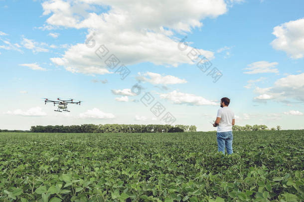 技术员农民使用 wifi 上网计算机控制农业无人机在绿色的田野上