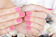 粉色磨砂修剪整齐的指甲的手