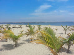 热带海滩与棕榈树, 沙子, 海洋水与小船和蓝天, 位于 Mussulo 海岛在罗安达, 安哥拉