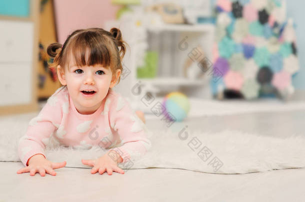 可爱快乐 2 岁<strong>小</strong>女孩玩玩具在家里。Pastele 音调，早期学习概念的现代幼儿园室内