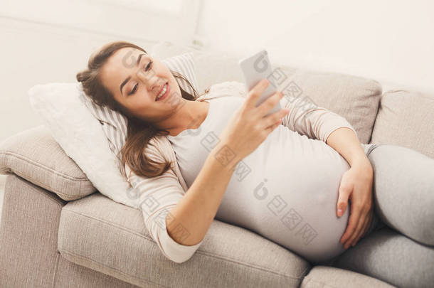 快乐怀孕妇女使用智能手机