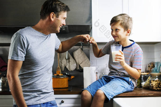 <strong>父子</strong>拳头在厨房里, 男孩拿着一杯牛奶