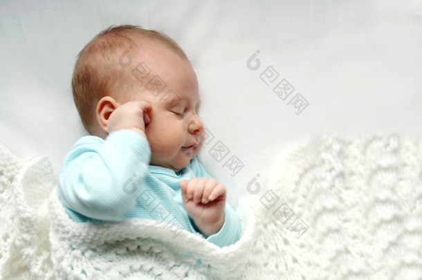 在白色的毯子里熟睡的刚出生的婴儿女孩
