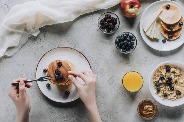 人吃美味的自制煎饼与浆果早餐的拍摄