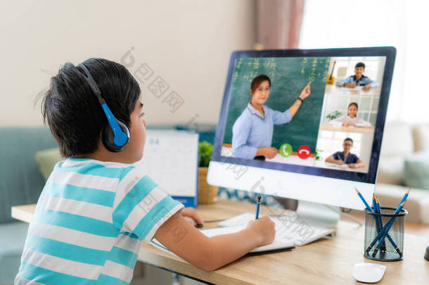 在家里客厅里，与老师和同学在电脑上进行电子学习。家庭学习和远程学习，在线、教育和互联网.