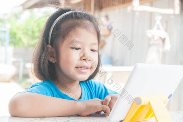 「数码无线装置」或「平板电脑」上的「亚洲女孩」网上学习课程或游戏，作为「科技电子学习」概念.