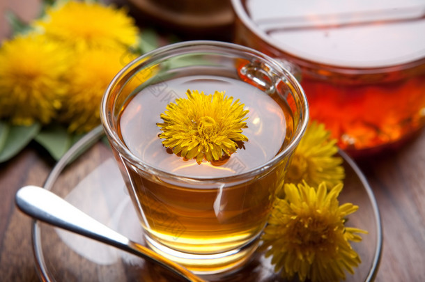 蒲公英茶和蜂蜜，木制的桌子上的黄色花朵,