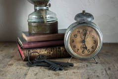 在家庭内部的静物细节。复古闹钟, 书籍, 在乡村风格的木制背景钥匙.