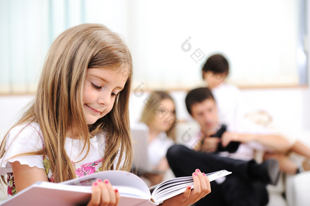 在家里，室内有幸福的家庭阅读的<strong>小</strong>女孩