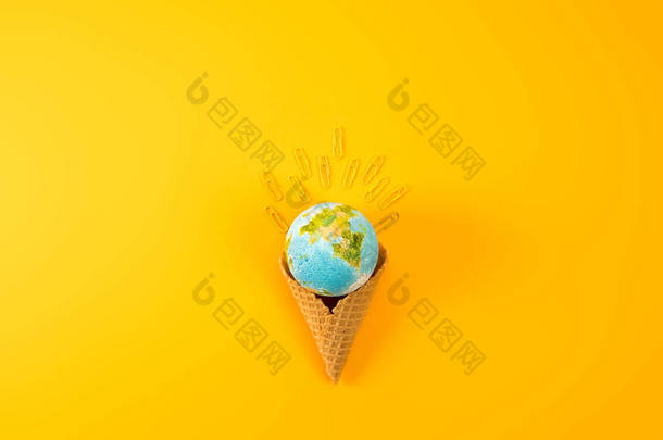 在黄色纸夹子的华夫饼锥中地球地球仪的顶部视图