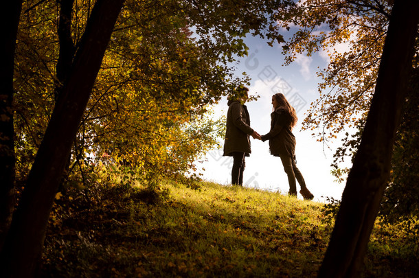 情侣牵手走在秋天的公园
