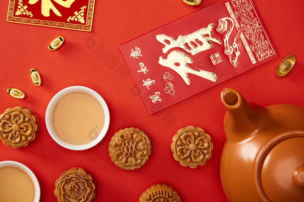 在红色上隔离的中国象形文字和茶的传统月饼的顶视图