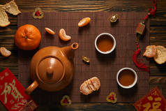 竹席上的茶具、橘子和中国传统装饰品的顶视图