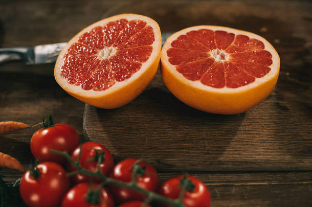 在木板上切柚子和樱桃西红柿在桌上