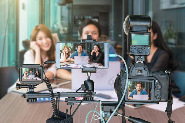 专业的相机与智能手机和动作摄像头的<strong>三脚架</strong>上的亚洲商界人士通过现场直播, 现场流的企业家概念