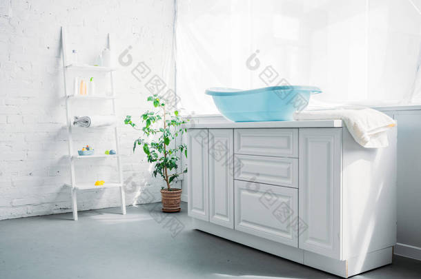 蓝色塑料儿童浴缸在白色现代房间的立场