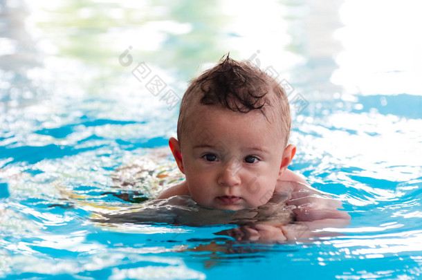 在<strong>温暖</strong>的<strong>室内</strong>游泳池游泳的宝宝